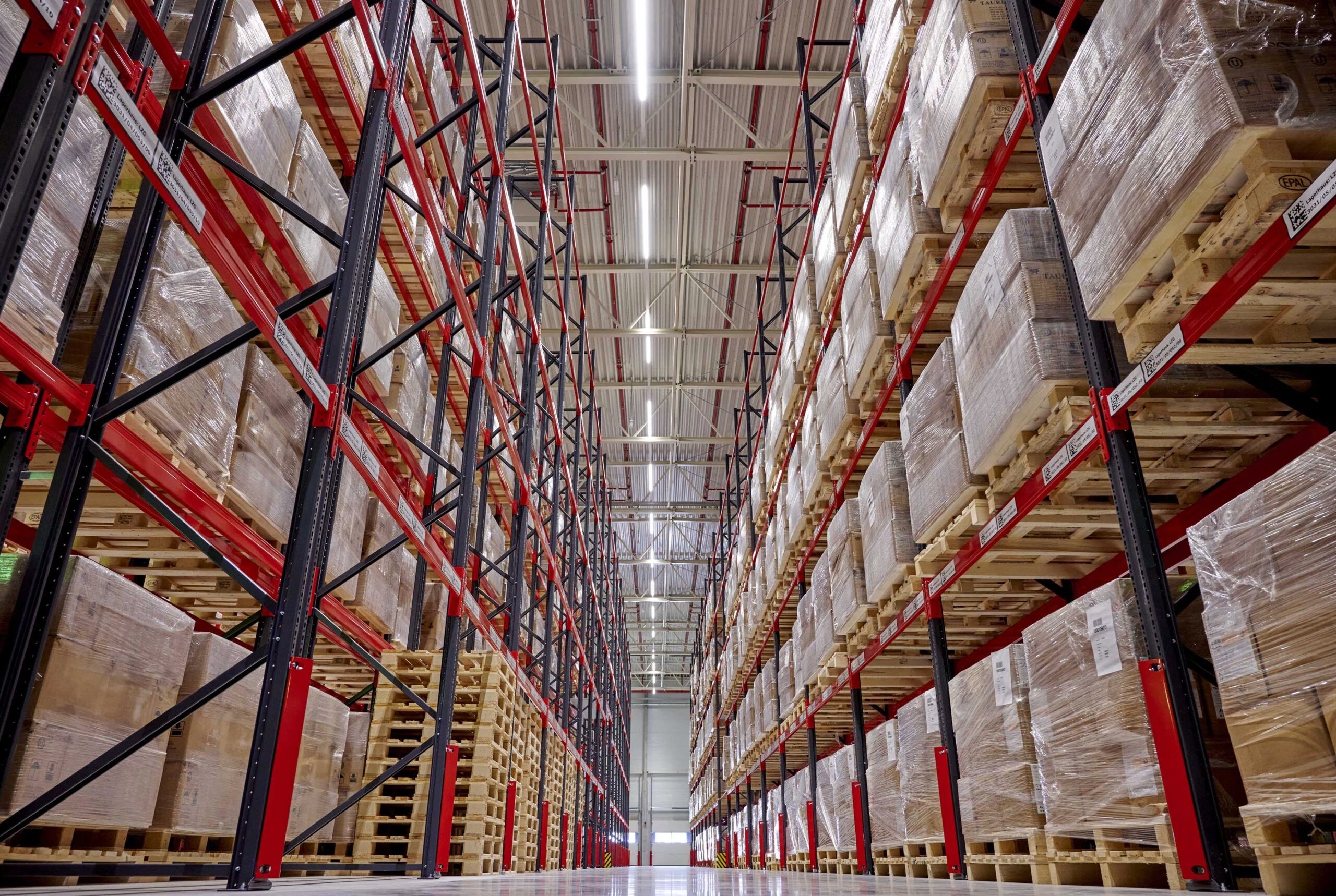 Volles Hochregallager in einer Logistikhalle bei Transco